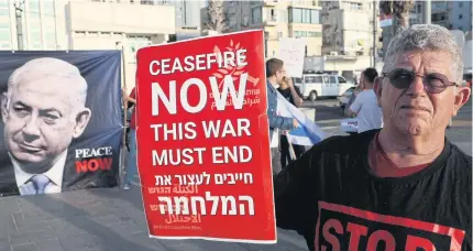  ?? AFP ?? People hold a banner during a protest in front of the US Embassy in Tel Aviv on Monday.