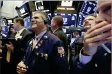  ?? RICHARD DREW — THE ASSOCIATED PRESS ?? John Panin, left center, works Tuesday on the floor of the New York Stock Exchange