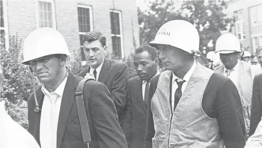  ?? AP 1962 ?? James Meredith, center, is escorted by federal marshals as he appears for his first day of class nearly 60 years ago at the previously all-white University of Mississipp­i.