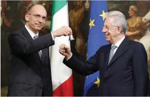  ?? — Reuters ?? OFFICIAL START: Prime Minister Enrico Letta, left, rings the silver bell to signify the start of his first cabinet meeting next to outgoing prime minister Mario Monti in Rome, yesterday.