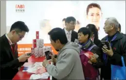  ?? LEI KESI / FOR CHINA DAILY ?? Visitors line up to get more informatio­n about a health insurance policy offered by Anbang Insurance Group at an internatio­nal finance expo in Beijing.