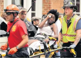  ??  ?? Rescue workers move victims on stretchers after a car ploughed through a crowd of counter-demonstrat­ors marching through Charlottev­ille