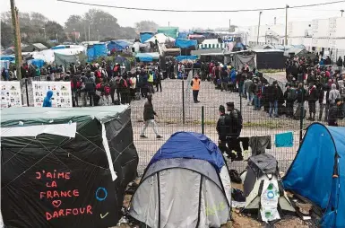  ?? — AFP ?? Moving out: Migrants queueing outside a hangar where they will be sorted into groups and put on buses for shelters across France, as part of the full evacuation of the Calais ‘Jungle’ camp.