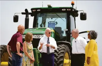  ?? Andrew Harnik / Associated Press ?? President Biden visits an Illinois farm accompanie­d by farm owners Jeff O’Connor (left) and his wife, Gina O’Connor, Agricultur­e Secretary Tom Vilsack and Rep. Robin Kelly, D-Ill.