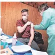  ?? RP-FOTO: ABZ ?? Maria Tann impft Feuerwehrm­ann Patrick Weber, der von einer übriggebli­ebenen, geöffneten Impfdose profitiert.