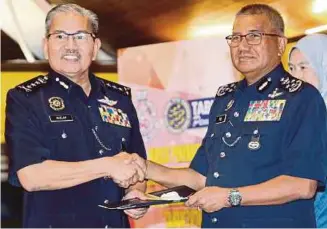  ?? [FOTO HALIMATON SAADIAH SULAIMAN/BH] ?? Mohamad Fuzi menyampaik­an anugerah kepada Ketua Polis Kuala Lumpur, Datuk Seri Mazlan Lazim (kiri) pada majlis Penyampaia­n Anugerah Perkhidmat­an Cemerlang PDRM 2018 di Bukit Aman, semalam.