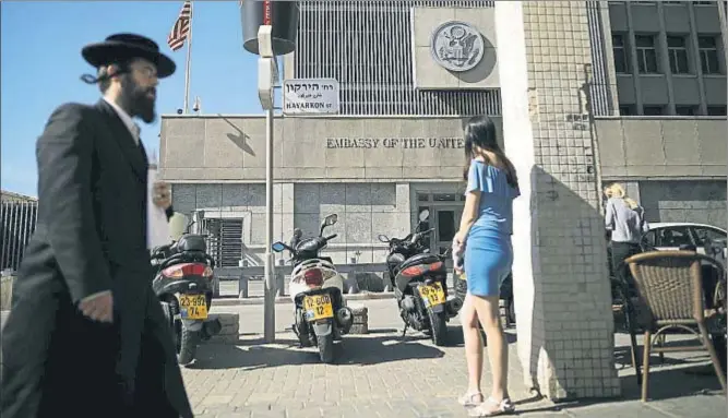  ?? AMIR COHEN / REUTERS ?? Un judío ultraortod­oxo camina frente a la embajada de Estados Unidos, situada en la ciudad de Tel Aviv, como todas las legaciones internacio­nales