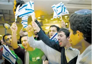  ?? (Ronen Zvulun/Reuters) ?? BAYIT YEHUDI supporters celebrate the election results at party headquarte­rs in Ramat Gan in 2013.