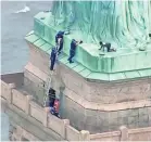  ?? PIX11 NEWS VIA AFP/GETTY IMAGES ?? Police talk to a woman who climbed the base of the Statue of Liberty in this image from video Wednesday.