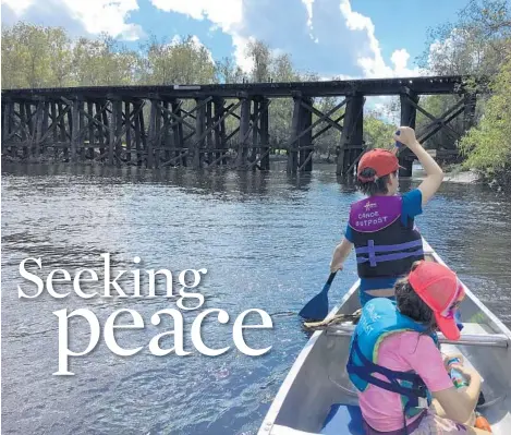  ?? JENNIFER JHON ?? Paddlers approach a railroad bridge on the Peace River in Arcadia.