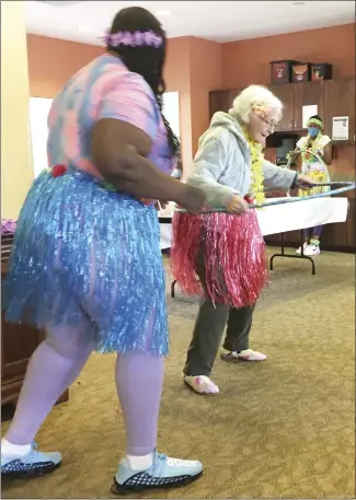  ?? Submitted Photo ?? LaToya Hughes helps Lois Ford with a hula hoop at facility recently held a Luau for it’s residents.
St. Francis County Assisted Living. The