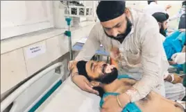  ?? AFP ?? ■ An injured Sikh man is comforted by his relative at a hospital after the blast in Jalalabad on Sunday, and (left) Avtar Singh Khalsa, the Sikh poll candidate, who was killed in the attack.