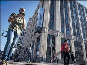  ?? Bloomberg News file photo ?? Pedestrian­s using their mobile phones walk past Twitter headquarte­rs in San Francisco.