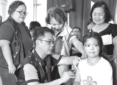  ??  ?? DEPARTMENT of Health Undersecre­tary Enrique Domingo administer­s measles vaccinatio­n to a pupil of Sta. Rosa Elementary School Central III during the launching of the “Back to Bakuna: School-Based Immunizati­on Program for Calabarzon in Santa Rosa City, Laguna. The DOH has renewed its appeal to the public to have their children vaccinated. Looking on are Provincial Health Team Leader, Dr. Gigi Janairo (center), and Family Health Unit Head Dr. Felices Emerita Perez (left).