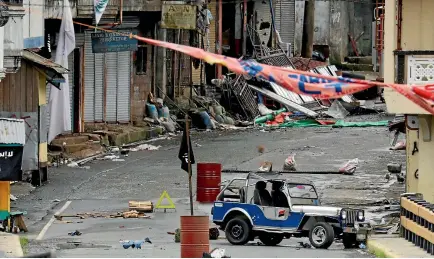  ?? PHOTO: REUTERS ?? An ISIS flag stands in the street where the militant Maute group has taken hold of Marawi City in southern Philippine­s.