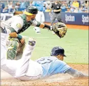  ?? JOSEPH GARNETT JR. — GETTY IMAGES ?? Tampa Bay’s Carlos Gomez slides safely into home plate to score in the seventh inning of Sunday’s game.