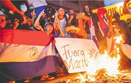 ?? CESAR OLMEDO/REUTERS ?? Decenas de manifestan­tes en diversas ciudades de Paraguay exigieron la renuncia, no solo del gabinete del Ejecutivo, sino también la del presidente Abdo Benítez