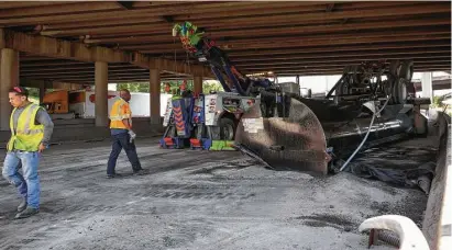  ?? Godofredo A. Vasquez / Houston Chronicle ?? Authoritie­s investigat­e the scene where a dump truck northbound on the Eastex Freeway struck an overpass at Loop 610, sending pieces of the truck flying. No one was seriously injured.