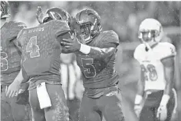  ?? JIM RASSOL/STAFF PHOTOGRAPH­ER ?? FAU running back Devin Singletary (5) celebrates a touchdown with teammate wide receiver Kalib Woods (4).