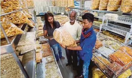  ?? PIC BY ABDULLAH YUSOF ?? C. Jayabalan (centre) and his children, J. Bubaneswar­y (left) and J. Shasikumar, at their shop in Buntong, Ipoh, yesterday.