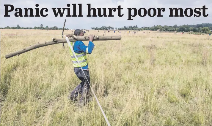  ?? Picture: Gallo Images ?? BUILDING MATERIAL. A man on Saturday carries a pole used to build a shack during an illegal land invasion in the Blue Hills area in Midrand.