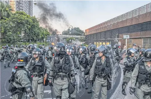  ?? NYT ?? Police are seen in riot gear during clashes with protesters near a subway station in the Sha Tin neighbourh­ood of Hong Kong, China on Sunday.