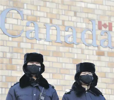  ?? GREG BAKER / AFP / GETTY IMAGES ?? Chinese police officers stand guard outside the Canadian embassy in Beijing on Monday.