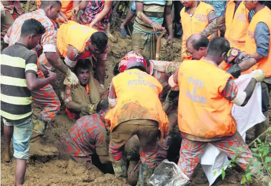  ?? AFP ?? Emergency workers extract a man trapped under mud and debris in Rangamati district yesterday. Authoritie­s said the landslides were the worst in Bangladesh’s history.
