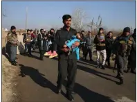  ?? (AP/Rahmat Gul) ?? An Afghan security officer carries his injured daughter after an attack in December near Bagram Air Base outside Kabul.