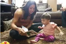  ?? TORONTO STAR FILE PHOTO ?? Above, Priscilla Lopes-Schliep reads to her daughter, Nataliya. Left, when Jill Viles of Iowa saw this photo online of Lopes-Schliep’s unusual physique — powerful shoulders but disproport­ionately thin legs — she realized she and the Olympic medallist...