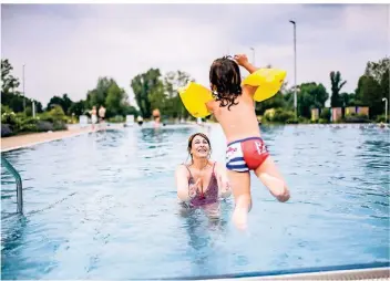  ?? FOTO: ANDREAS BRETZ ?? Und ab ins kühle Nass: Mutter Mela Sinani und Tochter Linda nutzten den ersten Freibad-Tag in Düsseldorf-Lörick, um sich zu erfrischen. In diesem und in weiteren Bädern gelten strenge Hygienereg­eln.