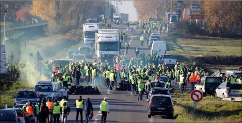  ??  ?? People wearing yellow vests, a symbol of a French drivers’ nationwide protest against higher fuel prices, block the Paris-Brussels motorway in Haulchin, France. — Reuters photo