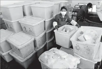  ?? XINHUA ?? Sorting staff sift medical waste at a garbage disposal site in Xinyu, Jiangxi province.