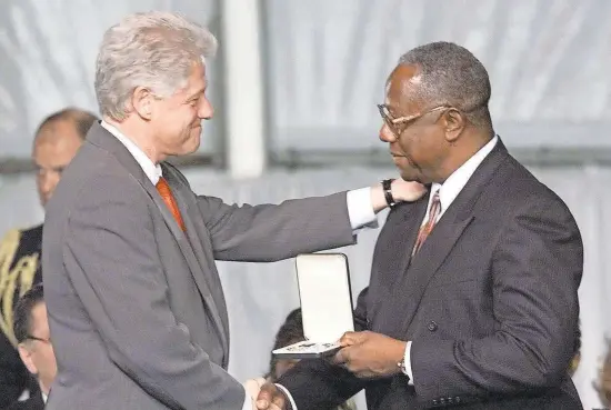  ?? H. DARR BEISER/USA TODAY SPORTS ?? President Bill Clinton presents Hank Aaron with a Presidenti­al Citizens Medal in a ceremony at the White House in 2001.