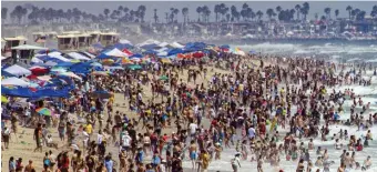  ?? AP FILE ?? SURFIN’ USA: Thousands of people converge on the beach during the U.S. Open of Surfing competitio­n in Huntington Beach, Calif. This year’s event has been canceled because of the coronaviru­s.