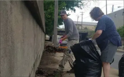  ?? KEITH REYNOLDS — THE MORNING JOURNAL ?? Eric Newsome, 35, and Sue Lamphere, 52, both of Lorain, worked together May 26 to clean up debris near the East 28th Street underpass in Lorain as part of the flash mob-like Quick Picks which seek to harness the community to clean up parts of the city.