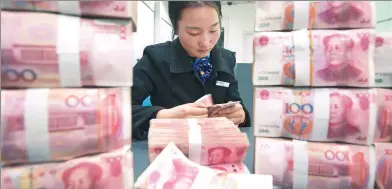  ?? XU JINBO / FOR CHINA DAILY ?? A clerk counts cash at a bank outlet in Hai’an county, Jiangsu province.