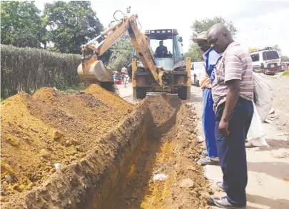  ??  ?? Harare Water supervisor Samuel Mapurisa (with hat) and a colleague assess progress on a trenching exercise in Mushongand­ebvu Walk, Mbare, yesterday. Harare City Council has moved in swiftly to replace old pipes in the wake of the recent suspected...