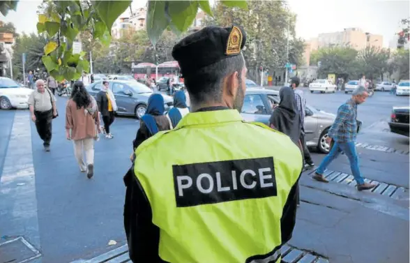  ?? Foto: E. P. ?? Un policía iraní vigila en una calle de Teherán que las mujeres utilicen el velo.