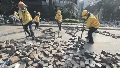  ?? Picture: EPA-EFE ?? PRO-DEMOCRACY FALLOUT. Crews clean up in the streets outside Hong Kong Polytechni­c University on the fourth day of a stand-off with police yesterday. The protests are a pro-democracy movement.