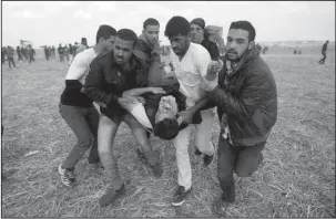  ?? The Associated Press ?? DEMONSTRAT­ION: Palestinia­n protesters evacuate a wounded youth during clashes with Israeli troops on Friday along the Gaza Strip border with Israel, east of Khan Younis, Gaza Strip.