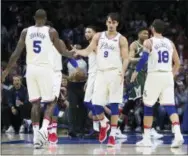  ?? CHRIS SZAGOLA — THE ASSOCIATED PRESS ?? The 76ers’ Dario Saric, center, celebrates with Marco Belinelli, right, and Amir Johnson, left, during the first half against Milwaukee Wednesday.