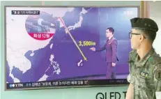  ?? — AFP ?? A South Korean soldier walks past a television screen showing a graphic of the distance between North Korea and Guam at a railway station in Seoul.