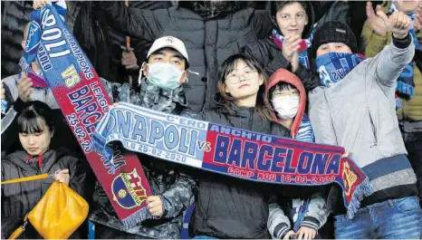  ?? FOTO: ANDREW MEDICHINI/DPA ?? Auch mit Mundschutz schaut es sich ganz gut: Asiatische Zuschauer treffen beim Spiel zwischen Neapel und Barcelona Vorsorge.