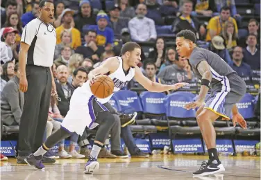  ??  ?? OAKLAND: Sacramento Kings guard Seth Curry (30) drives past Golden State Warriors guard Brandon Rush, right, during the second half of an NBA basketball game Saturday, in Oakland, Calif. The Warriors won 120-101. — AP