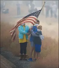  ?? The New York Times/TOM BRENNER ?? Children stand in the smoke by the side of the road Saturday as President Donald Trump’s motorcade passes through Chico, Calif.