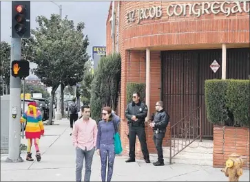  ?? Luis Sinco Los Angeles Times ?? ARMED GUARDS stand outside the Etz Jacob Congregati­on building Feb. 15, the day after a guard shot a so-called 1st Amendment auditor who often records YouTube videos from sidewalks near sensitive locations.
