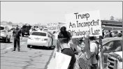  ?? Buy this photo at YumaSun.com PHOTO BY WARNER STRAUSBAUG­H/YUMA SUN ?? PROTESTERS HOLD UP SIGNS prior to President Donald Trump’s arrival at Marine Corps Air Station Yuma off East 32nd Street on Tuesday.