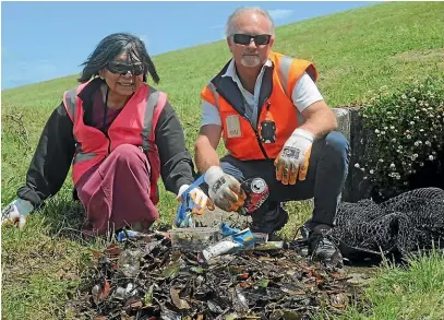  ??  ?? Sandy Beath-Croft and David Fahey sift through rubbish from a drain in Taita. The Hutt City Council estimates 10 tonnes of rubbish enters Wellington Harbour via Hutt drains every year.