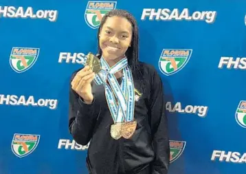  ?? PHOTOS COURTESY OF CARLOS COOPER ?? Left, Davie’s Cathy Cooper, a senior at American Heritage School, swims for the win in the girls 50-yard freestyle event at the Class 2A state championsh­ip tournament in Stuart. Above, Cooper shows off the gold medal she won. She recently signed her...